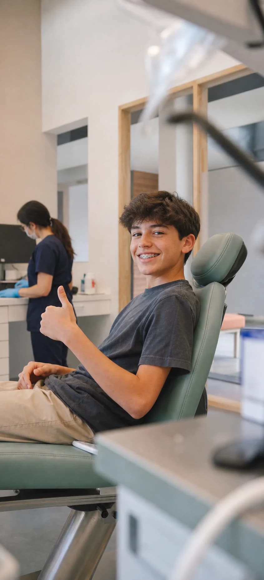 Een patiënt glimlacht tijdens een behandeling bij Ortho 20